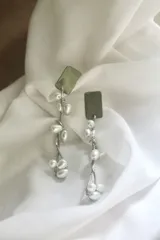 Aros colgantes plateados con base rectangular y perlas colgantes.