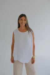 Musculosa blanca de lino italiano, de corte recto, con escote redondo y ruedo asimétrico.