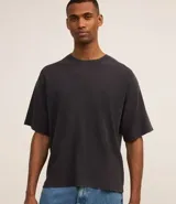 Remera negra de corte boxy con cuello redondo y mangas cortas. Tejido con textura waffle.