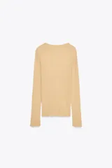 Top color beige de punto fino, con cuello barco y manga larga.