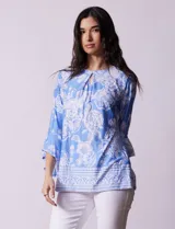 Blusa azul con estampado floral blanco, de seda fría, con cuello redondo con abertura y mangas 3/4 amplias con volados. Marca Ruby Rd.