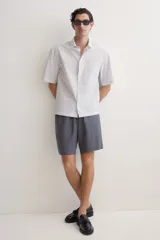 Short gris oscuro de lino y algodón, corte relaxed fit, con cintura elastizada ajustable con cordón, bolsillos laterales y bolsillo trasero.