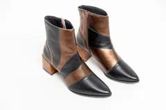 Botas cortas de cuero negro y bronce, con punta fina, cierre lateral y taco de madera.