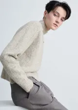 Sweater de punto grueso color crema, con cuello perkins y mangas largas.