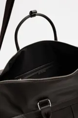 Bolso de viaje negro con acabado grabado, compartimento principal con cierre de cremallera, bolsillo interior con cierre de cremallera, bolsillo frontal con cierre de cremallera, asa de hombro removible y ajustable.