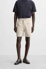 Bermuda negra regular fit confeccionada en tejido de algodón con estructura. Cintura elástica ajustable con cordón, bolsillos laterales y bolsillo trasero de vivo.