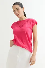 Remera fucsia de algodón con cuello redondo y detalle de broderie en el escote.