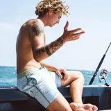 Short de baño celeste con cintura verde y cordón ajustable.