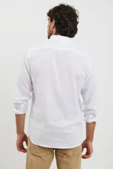 Camisa celeste de lino y algodón, de corte clásico, con cuello button-down y manga larga.