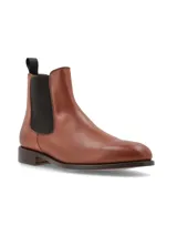 Bota Chelsea color marrón de cuero liso, con elásticos laterales negros y tirador trasero.