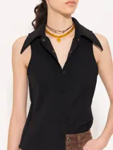 Camisa sin mangas confeccionada en tela de punto lisa, color negro, de corte regular. Lleva cartera con broches JCH y pinzas que entallan la prenda.