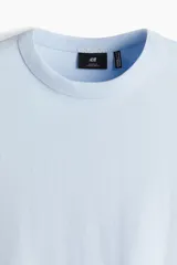 Remera celeste de corte holgado, cuello redondo ribeteado y mangas cortas. Confeccionada con tejido funcional COOLMAX®, una fibra de poliéster de secado rápido que elimina la humedad y regula la temperatura corporal.