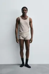 Conjunto de pijama color gris compuesto por una camiseta sin mangas de corte ajustado y un bóxer corto con cintura elástica y botones.