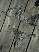 Conjunto de bikini turquesa con corpiño triangular de corte fijo, breteles regulables y almohadillas desmontables, y bombacha vedetina con frunce elástico en los costados.