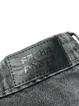 Bermuda de jean gris oscuro con efecto lavado, tiro alto y corte ancho (baggy) que termina a la altura de la media pierna (3/4). Presenta costuras marcadas en el frente de las piernas.