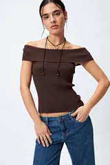 Top tejido color blanco con escote bardot que deja los hombros al descubierto y punto acanalado.