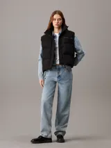 Chaleco puffer negro Calvin Klein Jeans con logo bordado en el pecho, cuello alto, cierre frontal con botones a presión y bolsillos laterales.