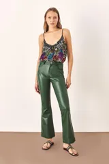 Pantalón de cuero verde, de corte recto y tiro alto.