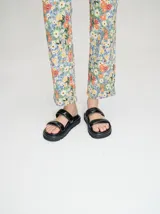 Sandalias blancas con doble tira ancha y plataforma negra.