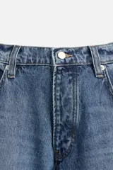 Pantalón de jean negro de corte amplio, estilo balloon fit, con cinco bolsillos, efecto lavado y cierre frontal con botones.