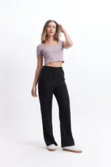 Pantalón de vestir color crema, de tiro medio, corte recto y pierna ancha.