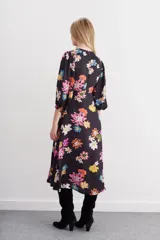 Vestido midi negro con estampado de flores grandes y coloridas (rosado, naranja, amarillo, blanco, azul). Presenta mangas balloon, escote redondo con tablas y ajuste en la cintura con lazo.