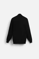 Jersey negro de punto fino con cuello alto y manga larga.