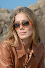 Lentes de sol Vulk Pretend, de industria Argentina, con marco rectangular color naranja traslúcido y lentes polarizados.