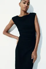 Vestido midi negro de punto arrugado con mangas japonesas y escote barco. Diseño ajustado con laterales fruncidos para un efecto drapeado que realza la figura.