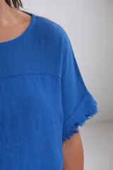 Remera azul francia de lino italiano, con escote redondo y mangas cortas con detalle desflecado.