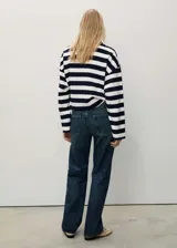 Pantalón de jean azul oscuro, de corte recto, tiro medio y cinco bolsillos.