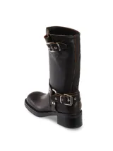 Bota de cuero negra de media caña con hebillas plateadas en el tobillo y en la parte superior de la caña.