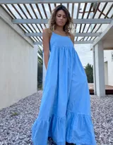 Maxi vestido celeste de jean con breteles regulables y bolsillos laterales.