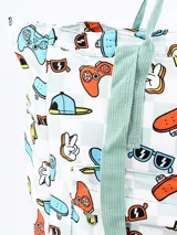 Mochila blanca con estampado de videojuegos, patinetas, gafas de sol y otros motivos. Tiene asas de mano y tirantes de color verde agua.