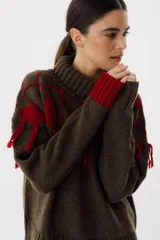 Sweater tejido de punto color crudo con cuello alto y diseño de rombos marrones con flecos.