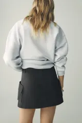 Sudadera gris melange de cuello redondo y manga larga con puños elásticos. Estampado frontal con texto "Chicago Harlem" y dibujo de Betty Boop.