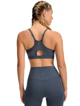 Top deportivo de sujeción baja, color gris azulado, con breteles finos y espalda deportiva.