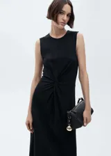 Vestido midi negro sin mangas, de corte recto y cuello redondo, con detalle drapeado en la cintura.