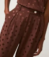 Pantalón recto marrón con estampado de mini hojas, cintura alta con trabillas y botón.