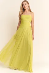 Vestido largo de fiesta color amarillo, con breteles finos, escote recto, corte en la cintura y falda amplia de tul.