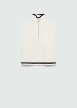 Chaleco de punto color crudo, con cuello polo y cierre de cremallera metálica. Tiene diseño sin mangas y ribete a rayas en el bajo.