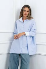Camisa oversize celeste a rayas verticales blancas, con cuello y puños blancos.