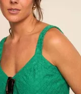 Blusa corta color verde esmeralda, con escote en pico y tirantes medianos con abalorios. Confeccionada en tejido laise texturizado y elástico en la espalda.