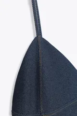 Vestido midi de denim azul con tirantes finos, escote en pico y pespuntes a contraste.