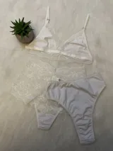 Conjunto de lencería blanco de tres piezas: bralette de lycra y encaje, bombacha de lycra tiro alto y hipster de encaje.