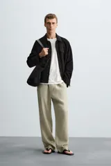Sobrecamisa color beige de tejido efecto ante, corte regular fit, con cuello solapa, manga larga con puños abotonados, bolsillos de parche con solapa en el pecho y bolsillos de ojal en la cadera.