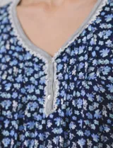 Conjunto de pijama marca René Rofé, compuesto por short y remera de tejido soft estampado con flores rosas sobre fondo blanco. Remera de escote en V con aplique de puntilla, botones y detalle plisado. Short con cintura elastizada.