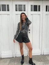 Short negro de cuerina con pinzas delanteras y cierre con botón.