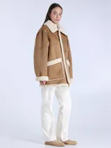 Chaqueta reversible de piel de oveja color crema con botones cuadrados de cuero marrón y bolsillos delanteros.