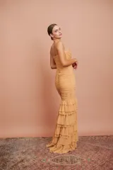 Vestido largo color durazno, entallado, con escote en V, breteles finos, drapeado en el frente y falda con volados.